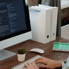 Kobieta pisze na klawiaturze przed monitorem z recenzjami gier Steam.