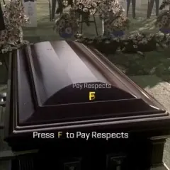 Na cmentarzu trumna, obok zdjęcie zmarłego. Na trumnie napis "Press F to Pay Respects".