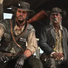 Dwóch kowbojów, jeden młodszy, drugi starszy, siedzi pod wiatą. Scena z gry Red Dead Redemption 2 PC.