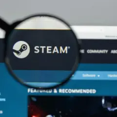 Lupa powiększa logo Steam na ekranie komputera.