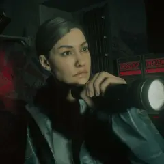 Saga Alan Wake 2 DLC: Agentka z latarką bada mroczne korytarze, gdzie migają czerwone napisy "EMERGENCY - SEEK SHELTER".