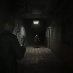 Mroczny korytarz szpitalny, gracz z pistoletem mierzy do przerażającej pielęgniarki. Klimat jak w najlepszych grach horror ps5.