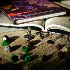 Księga D&D, kostki i figurki na mapie – wszystko gotowe na epickie gry RPG.