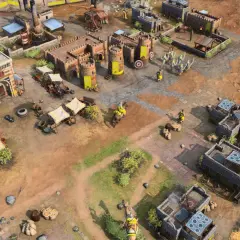 Scena z gry rts: zamek, budynki, rycerze w żółtych strojach, wozy i targowisko.