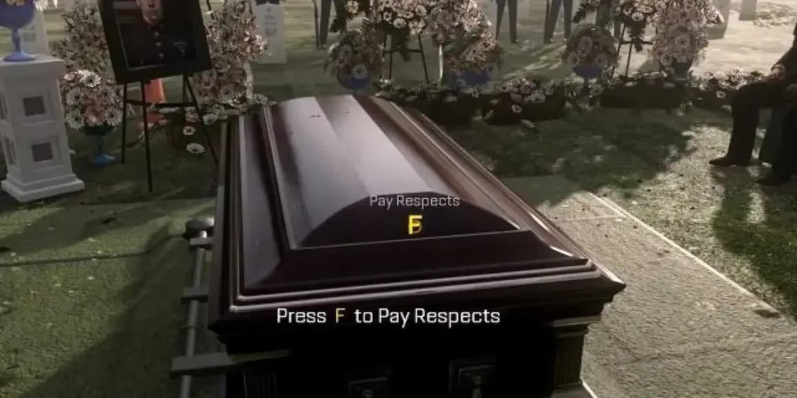 Na cmentarzu trumna, obok zdjęcie zmarłego. Na trumnie napis "Press F to Pay Respects".