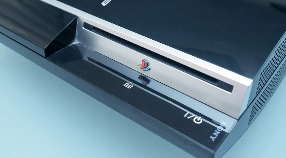 Konsola PlayStation 3, kiedy wyszło PS3, z kolorowym logo PlayStation i przyciskami zasilania i eject.