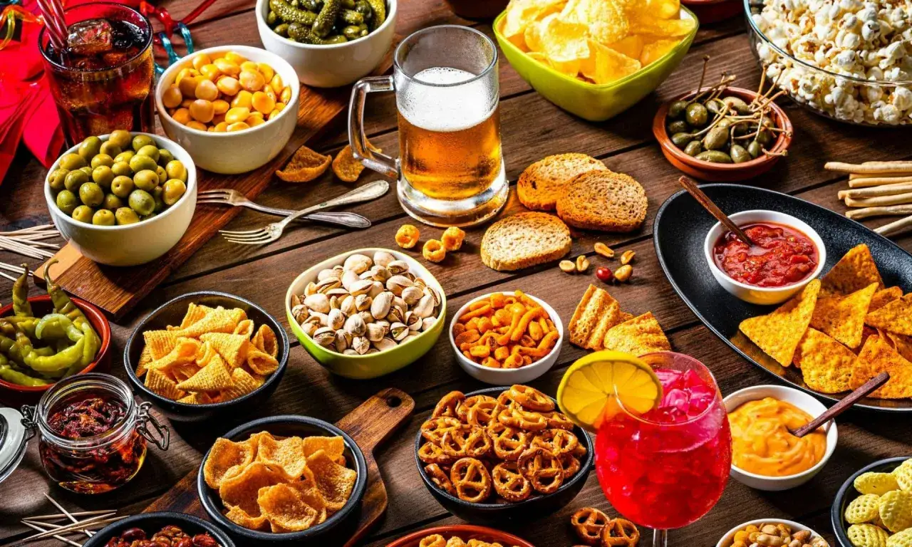 Idealne przekąski na wieczór z grami ze znajomymi: piwo, chipsy, nachosy, oliwki, pistacje i wiele innych.