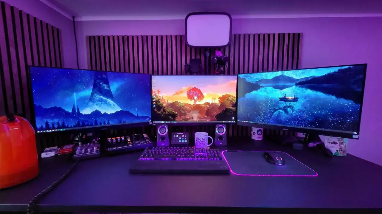 Stolik gracza z trzema monitorami, klawiaturą i myszką. Idealne miejsce do grania w gry na PC za darmo.