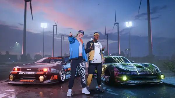 Dwóch graczy z najnowszego Need for Speed pozuje przy zmodyfikowanych autach na tle wiatraków i nocnego nieba.