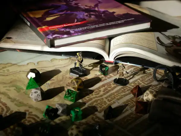 Księga D&D, kostki i figurki na mapie – wszystko gotowe na epickie gry RPG.